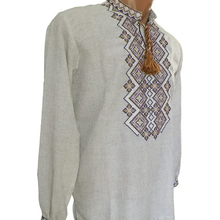 Two traditional Ukrainian embroidered shirts for men displayed on mannequins, one with long sleeves and one with short sleeves, featuring geometric patterns in red and blue on a linen fabric.