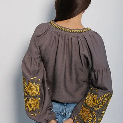 Women's embroidered blouse in graphite color with smooth floral patterns on the sleeves